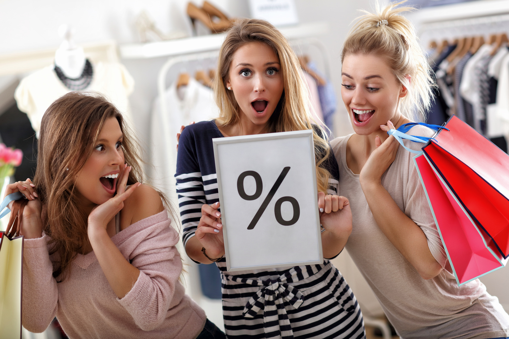 Group of happy friends shopping in store